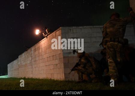 British Army reservists from the 3rd Battalion, Royal Anglian Regiment, known as “The Steelbacks,” conduct a simulated company-level urban operations night attack during Exercise Northern Strike 24-2 at the Combined Armed Collective Training Facility, Camp Grayling, Michigan, Aug. 12, 2024. Northern Strike 24-2, one of the Department of Defense's largest reserve component readiness exercises, is scheduled to take place at Michigan's National All Domain Warfighting Center (NADWC) from August 3-17, 2024. Over 6,300 participants from 32 states and territories and several international participant Stock Photo