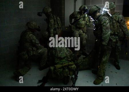 British Army reservists from the 3rd Battalion, Royal Anglian Regiment, known as “The Steelbacks,” conduct a simulated company-level urban operations night attack during Exercise Northern Strike 24-2 at the Combined Armed Collective Training Facility, Camp Grayling, Michigan, Aug. 12, 2024. Northern Strike 24-2, one of the Department of Defense's largest reserve component readiness exercises, is scheduled to take place at Michigan's National All Domain Warfighting Center (NADWC) from August 3-17, 2024. Over 6,300 participants from 32 states and territories and several international participant Stock Photo