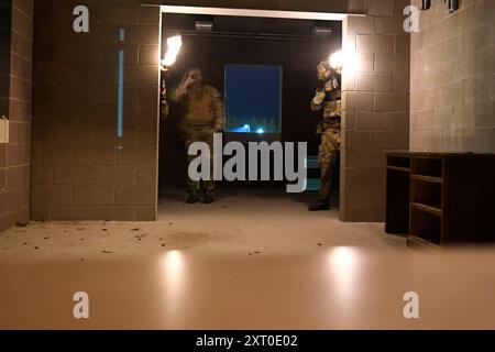 British Army reservists from the 3rd Battalion, Royal Anglian Regiment, known as “The Steelbacks,” conduct a simulated company-level urban operations night attack during Exercise Northern Strike 24-2 at the Combined Armed Collective Training Facility, Camp Grayling, Michigan, Aug. 12, 2024. Northern Strike 24-2, one of the Department of Defense's largest reserve component readiness exercises, is scheduled to take place at Michigan's National All Domain Warfighting Center (NADWC) from August 3-17, 2024. Over 6,300 participants from 32 states and territories and several international participant Stock Photo