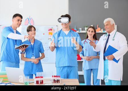 Male medical student with surgical instruments using VR glasses at lecture Stock Photo