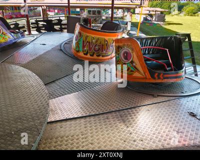 Here's a spooky site - a deserted funfair. Not derelict, but seen at dawn, the only time you will see it like this. It's at Rye Farm Fields by the banks of the Thames at Abingdon on  a fine summer morning.  This is a Waltzer, a rotating ride that often forms the centerpiece of English and Irish Fairs. It's a type of carousel, and also known as a Whirlygig. So there. Stock Photo