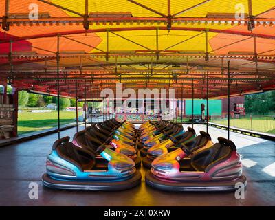 Here's a spooky sight - a deserted funfair. Not derelict, but seen at dawn, the only time you will see it like this. It's at Rye Farm Fields by the banks of the Thames at Abingdon on  a fine summer morning. And these, of course, are the dodgem carts, stationary for once. Stock Photo