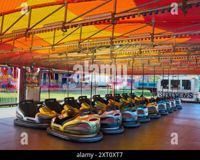 Here's a spooky sight - a deserted funfair. Not derelict, but seen at dawn, the only time you will see it like this. It's at Rye Farm Fields by the banks of the Thames at Abingdon on  a fine summer morning. And these, of course, are the dodgem carts, stationary for once. Stock Photo