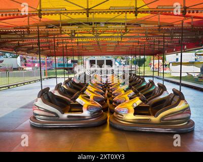 Here's a spooky sight - a deserted funfair. Not derelict, but seen at dawn, the only time you will see it like this. It's at Rye Farm Fields by the banks of the Thames at Abingdon on  a fine summer morning. And these, of course, are the dodgem carts, stationary for once. Stock Photo