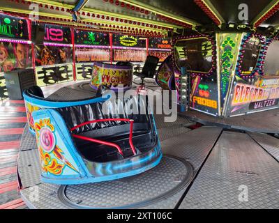 Here's a spooky site - a deserted funfair. Not derelict, but seen at dawn, the only time you will see it like this. It's at Rye Farm Fields by the banks of the Thames at Abingdon on  a fine summer morning.  This is a Waltzer, a rotating ride that often forms the centerpiece of English and Irish Fairs. It's a type of carousel, and also known as a Whirlygig. So there. Stock Photo