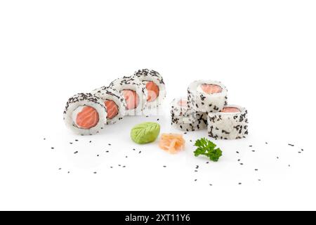 Elegant arrangement of salmon sushi rolls sprinkled with black sesame seeds, accompanied by wasabi and pickled ginger, isolated on a white background Stock Photo