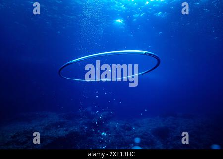 Underwater view of air ring and bubbles floating in transparent crystal blue ocean on sunny day at Menorca Stock Photo