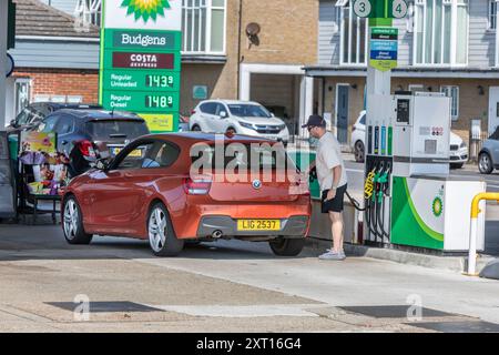 A man filling his car with fuel in a petrol station. Stock Photo