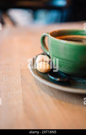 Waking Green Cup of Black Coffee Sitting on a Wooden Table With Two Biscuits as Sweets Added to the Brewed Caffeine Hit Stock Photo