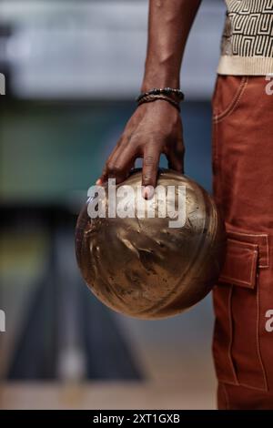 Closeup of persons hand holding bowling ball ready for throw on bowling lane with blurred background Stock Photo