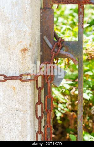 Closed padlock on a rusty iron chain close up Stock Photo