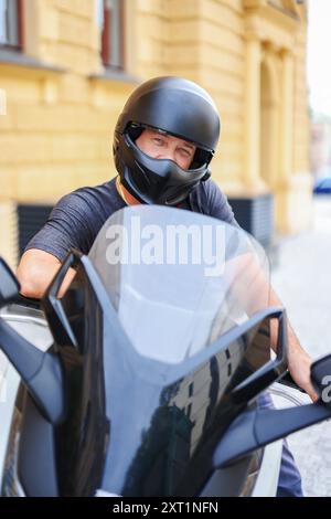 Biker in a helmet and leather protective equipment sits on a motorcycle, a sporty fast motorcycle Stock Photo