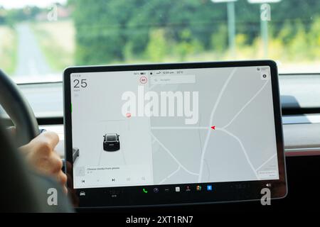 Person driving a Tesla car with GPS navigation Stock Photo
