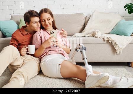 Woman with prosthetic leg enjoys coffee with boyfriend, looking at phone. Stock Photo