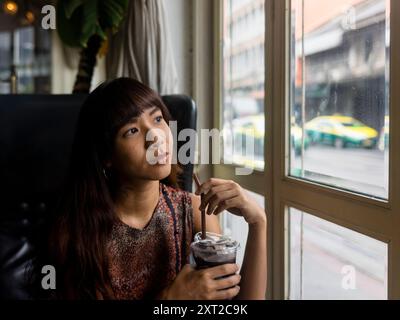 Young asian woman drinking iced tea released Stock Photo
