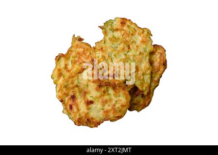 Vegetable zucchini fritters with garlic, salt, spices and herbs with white sauce on a dark concrete background Stock Photo