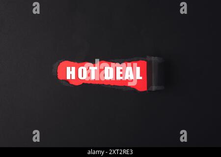 A red and black sign that says Hot Deal. The sign is torn in half, with the word Hot Deal written in red on the torn part Stock Photo