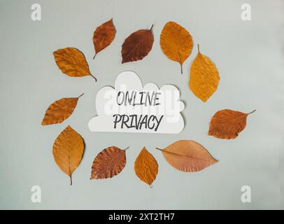 A white cloud with leaves surrounding it and the word online privacy written in black Stock Photo