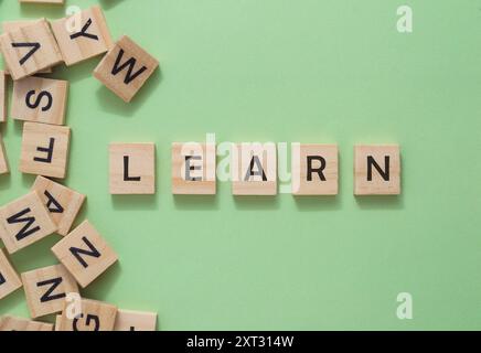 A pile of wooden blocks with the letters learn written on them. The blocks are scattered around the letters, creating a playful and educational atmosp Stock Photo