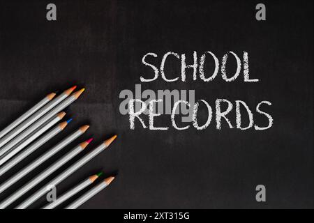 School records are written on a blackboard. The pencils are arranged in a row, and the chalk is used to write the words. Concept of education and lear Stock Photo