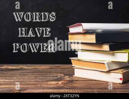 A stack of books with the words words have power written on top. The image conveys the idea that words have the ability to influence and impact people Stock Photo