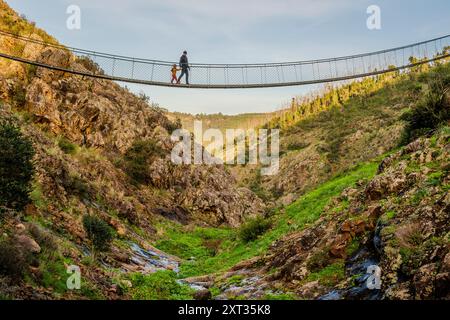 Father and son walking on hanging bridge in Alferce, Algarve, Portugal Stock Photo