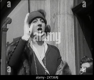 The Actress Violet Loraine Making a Passionate Speech Outside a Theatre, 1920s. 'After lunch, the charity matinees begin. Violet Loraine as barker for a show on behalf of the wounded of World War I...The aim? Well a full house of course'. From &quot;Time To Remember - On Stage in the Twenties&quot;, 1927 (Reel 2); a look behind the scenes of the theatre during the 1920's. Stock Photo