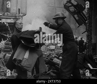 Men Clearing Out Possessions from a Bombed Out Building, 1940. Britain during the Second World War: the Blitz. 'Any night, any time, summer 1940. Fire and flame, death and destruction...Any morning-after in London - or is it Coventry, Bristol, Portsmouth? Liverpool, Belfast, Birmingham? Plymouth or Glasgow?...Yesterday was the old order of things. Today is different, just as tomorrow will be different, because it has to be'. From &quot;Time To Remember -  Standing Alone&quot;, 1940 (Reel 4); documentary film about events of later months of 1940. Stock Photo