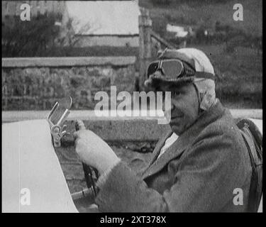 Close up Shot of John Godfrey Parry-Thomas Behind the Wheel of a Car Wearing a Racing Helmet, 1927. Welsh engineer and racing driver JG Parry-Thomas in 'Babs', the car in which he suffered a fatal crash at Pandine Sands while attempting to regain the world land speed record from Malcolm Campbell. From &quot;Time To Remember - Fast And Far  in the Twenties&quot;, 1927 (Reel 1); a look at the obsession with speed and travel during the late 1920s. Stock Photo