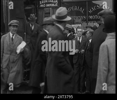 Civilians Disembarking from a Bus On the Streets of London, 1920s. From &quot;Time To Remember - Fast And Far  in the Twenties&quot;, 1927 (Reel 1); a look at the obsession with speed and travel during the late 1920s. Stock Photo