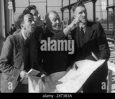 American Engineers Going Over Construction Plans of a Hangar at an Airfield in England, 1943-1944. From "Time To Remember -  Round The Clock", 1943 - 1944 ( Reel 1); documentary film about events of 1943-1944, mainly bombing missions over Europe. Stock Photo