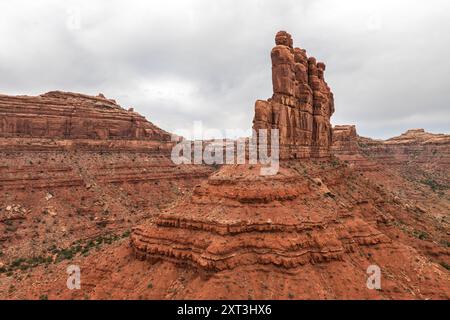 Captivating aerial view of the iconic red rock formations in Valley of the Gods, set against a cloudy sky, located in Utah, USA Stock Photo