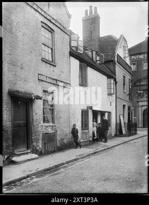 Brewhouse Lane, Putney, Wandsworth, Greater London Authority, 1912. A group standing outside a house on Brewhouse Lane with The Castle public house at the junction of Putney Bridge Road. A detail from this photograph appears in 'William Fields's Photographs of Putney', compiled by Dorian Gerhold and Michael Bull for the Wandsworth Historical Society. Stock Photo