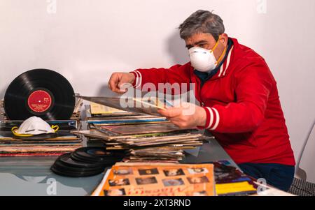 Modugno, Italy - 12 march 2020: At home for the coronavirus pandemic quarantine COVID-19. Passionate audiophile orders his collection of vinyl Stock Photo