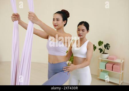 Practicing Aerial Yoga with Instructors Guidance Stock Photo