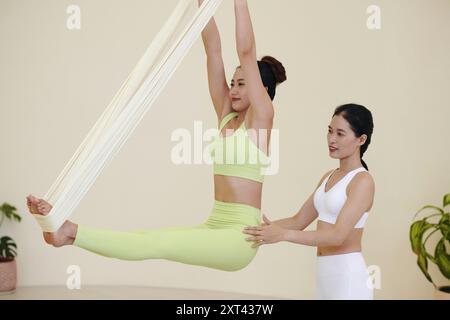 Practicing Aerial Yoga with Instructors Guidance Stock Photo