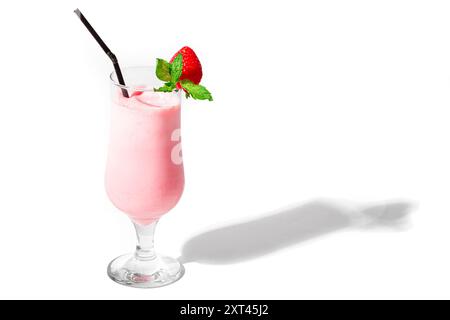 Glass of fresh strawberry milkshake, smoothie with mint and fresh strawberry isolated on white background, hard shadow, copy space. Pink blended cream Stock Photo
