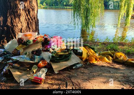 Garbage on the shore of the lake. Garbage dump in pond. City dump on the territory of the river. Environmental pollution by household waste. Stock Photo