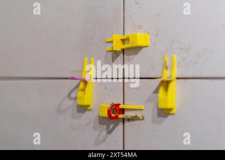 Tile leveling system with plastic clips and wedges in action. Ensures precise Stock Photo