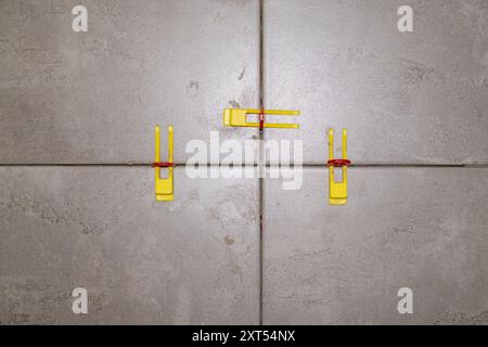 Close-up of tile leveling system with plastic clips and wedges in place.  Stock Photo