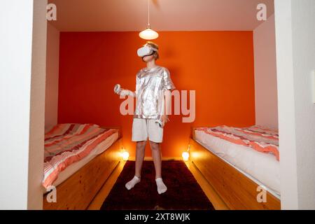 Boy using VR headset in bedroom Stock Photo