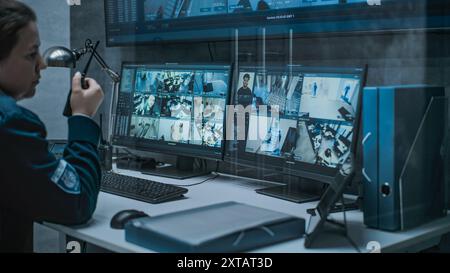 Multiple monitors and big digital screen showing surveillance video footage. Female dispatch or CCTV operator works on computer in monitoring center with security cameras, talks by walkie talkie. Stock Photo