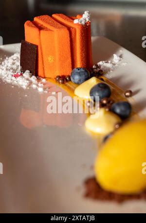 high cuisine dessert consisting of a carrot sponge cake decorated with berries, sugar and chocolate. Copy space Stock Photo