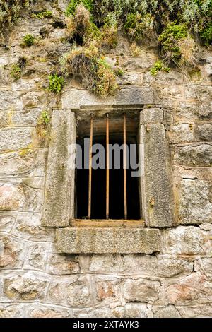 Old window with a grille on a stone house. Stock Photo