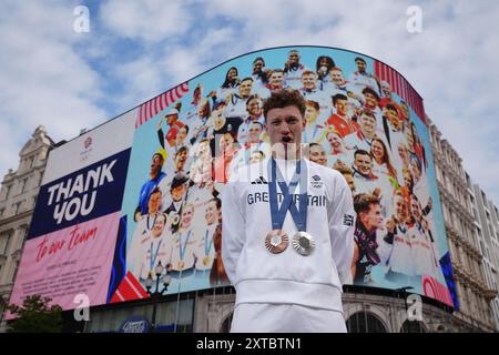 Diver Noah Williams poses with his Olympic medals in front of the
