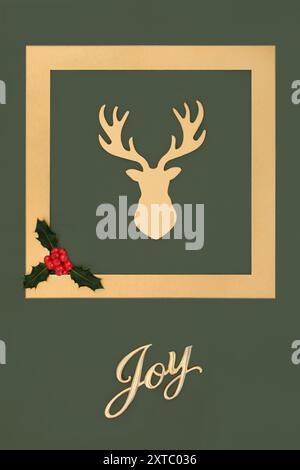 Christmas reindeer with gold joy sign and holly on green background with frame border. Cherished magical symbol of Xmas Eve santa helper. Stock Photo