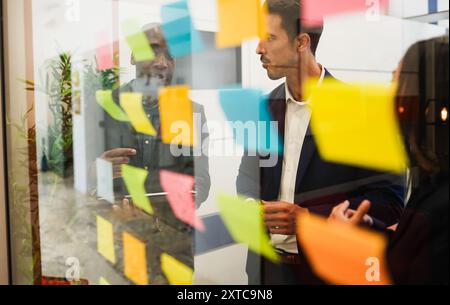 Multiracial colleagues working inside business office with glass walls - Entrepreneurs people sharing ideas at teamwork meeting - Brainstorming Stock Photo