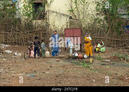 local villagers at the communal water pump Photographed in Madhya Pradesh, India in May Stock Photo