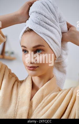 A young woman in a robe relaxes at home, her hair wrapped in a towel after a shower. Stock Photo