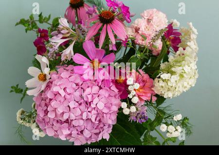 A bouquet of summer flowers in the room. Hydrangea, rose, echinacea, mint, snapdragon, asparagus and other flowers. Stock Photo